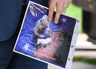 Ein Mann hält einen Ausdruck der fotorealistischen Collage des Sprechers des chinesischen Außenministeriums in der Hand