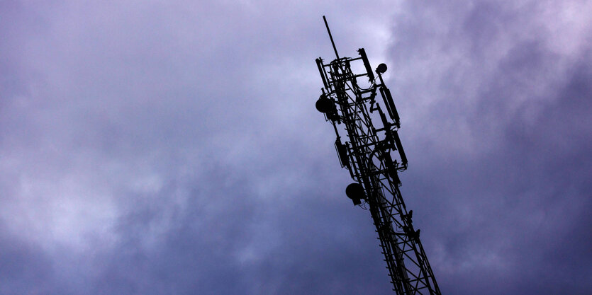 Mobilfunkantene vor violettem Himmel mit Wolken