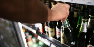 Ein Mann holt eine Flasche Bier aus einem Kühlschrank in einem Spätkauf in Berlin-Mitte