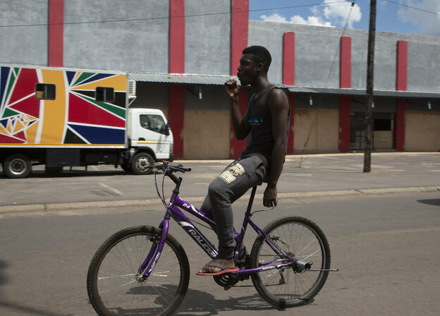 Ein junger Mann fährt mit seinem Fahrrad vor der mobilen Klinik, die vom Reproduktive Gesundheits- und HIV-Institut (RHI) in Soshanguve, nördlich von Pretoria betrieben wird