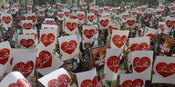 Plakate mit "Mohammed"- Herzen werden bei einer Demonstration gegen Emmanuel Macron in Lahore, Pakistan von vielen Menhscen hochgehalten