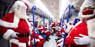 Blick in einen Wagon der Londoner Tube, in dem nur Weihnachtsmänner in ihrem bekannten Outfit sitzen