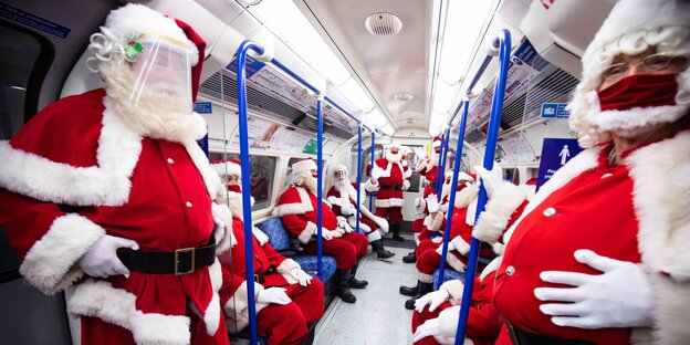 Blick in einen Wagon der Londoner Tube, in dem nur Weihnachtsmänner in ihrem bekannten Outfit sitzen
