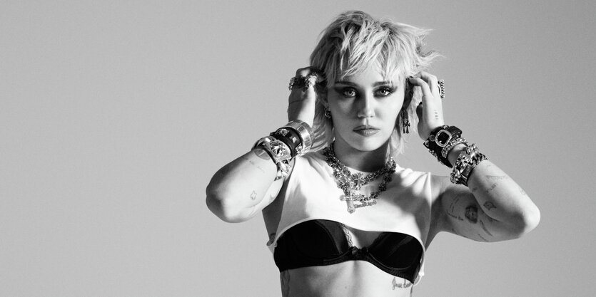 Miley Cyrus in Pose, mit den Fingern an den Ohren