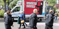 Polizisten vor einem "Kapitalisten enteignen"-Transparent