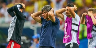 Joachim Löw und einige Nationalspieler gehen traurig über den Platz