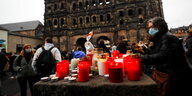 Kerzen und Menschen vor der Ruine eines alten Gebäudes