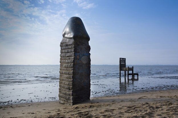 Phallus-Skulptur aus Stein am Strand des Nordseebads Dangast