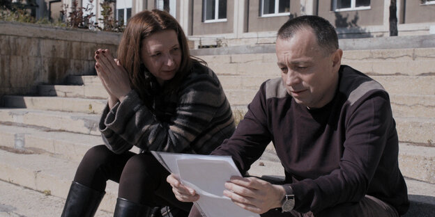 Die Investigativ­­jour­na­lis­t*in­nen Cătălin Tolontan und Mirela Neag bei der Arbeit mit Laptop im Freien.