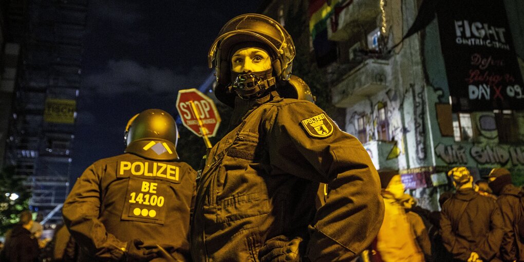 Polizisten und Polizistinnen sthen vor einem bestzten haus in der Berliner Liebigstraße