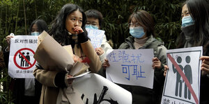 Zhou Xiaoxuan läuft neben Unterstützerinnen mit Plakaten am Mittwoch vor dem Gericht in Peking entlang und weint