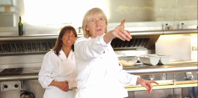 Zwei Frauen in weißer Kleidung stehen in einer Restaurantküche