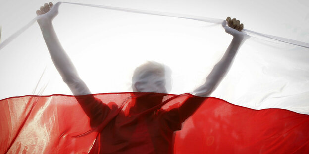 Silhouette eines Menschen hinter einer belarussischen Flagge