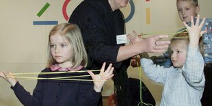 Kinder beim sogenannten Fadenspiel