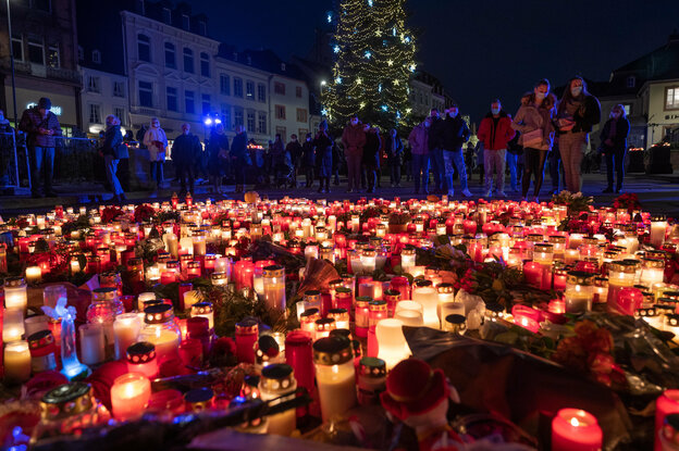 Menschen gedenken am Abend vor der Porta Nigra für die Opfer einer Amokfahrt und stellen Kerzen ab