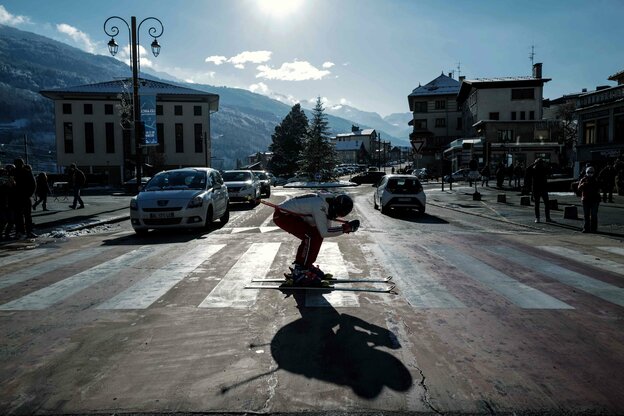 Ein Skifajrer mitten auf einer Straße fährt über einen Zebrastreifen um für die Wiedereröffnung der Skigebiete in den französischen Alpen zu demonstrieren