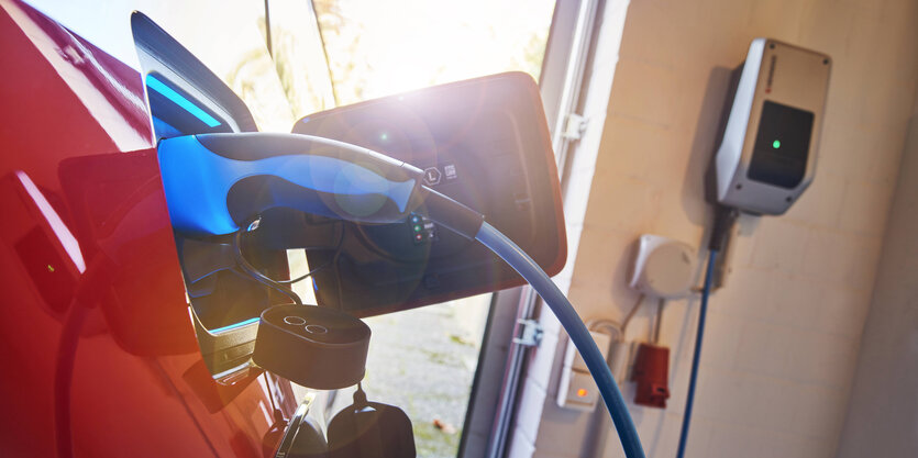 Ladestecker steckt im Elektroauto beim Laden an der Wallbox zuhause in der Garage