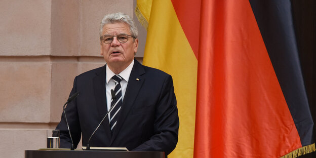 Joachim Gauck an einem Rednerpult vor einer Deutschlandfahne