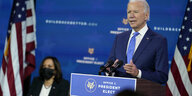 Joe Biden spricht an einem Redepult, im Hintergrund sitzt Kamala Harris