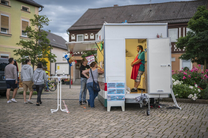 Ein Mann steht in einem Wagen auf einem Kirchweihfest