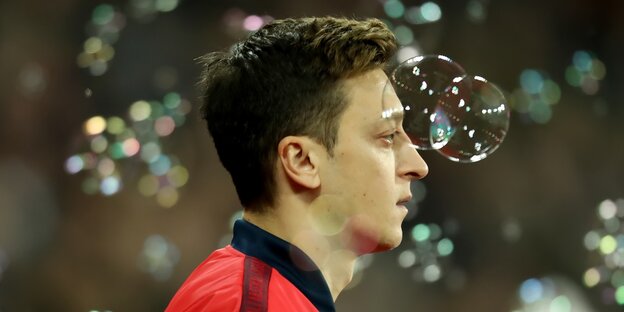 Özil mit Seifenblasen vor dem Gesicht