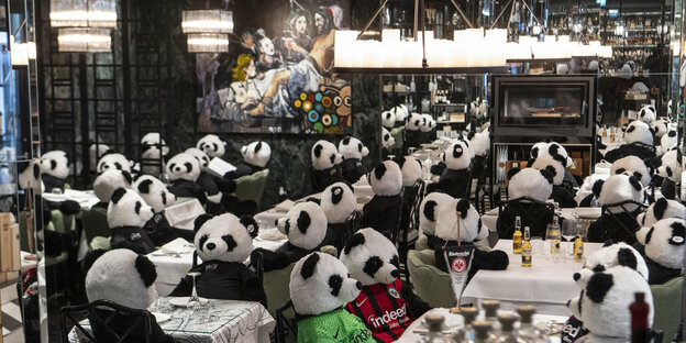 Pandabären aus Plüschsitzen in einem Restaurant
