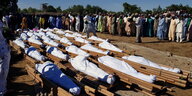 Beerdigung von mehreren in weiße Leintücher gewickelten Leichen
