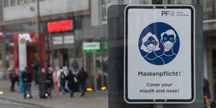 Ein Schild weißt in der Innenstadt Pforzheim auf die Maskenpflicht hin.