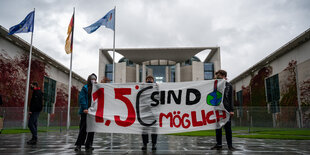 Demonstranten stehen bei einer Kundgebung von Fridays for Future mit einem Transparent mit der Aufschrift "1,5C sind möglich" vor dem Bundeskanzleramt.