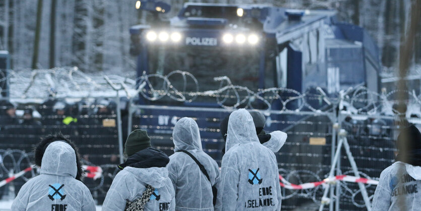 Aktivisten stehen vor einem Polizei-Wasserwerfer. Im Dannenröder Forst haben Ausbaugegner am Samstag erneut Barrikaden errichtet und Pyrotechnik abgebrannt. Nach Angaben der Polizei blockierten sie unter anderem die Not- und Rettungswege eines angrenzende