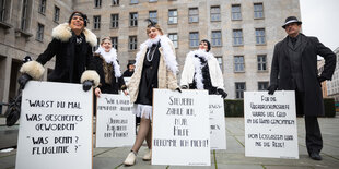 Frauen und Mäner in 20er Jahre Kleidung und Plakaten