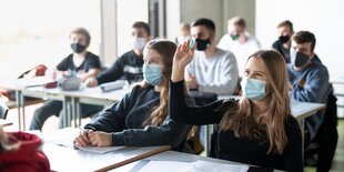 Schüler*innen sitzen eng nebeneinander im Klassenraum