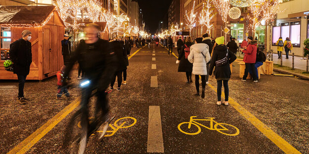 Flaniermeile mit Weihnachtbeleuchtung, Fußgängern und Radfahrern