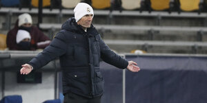 Zinedine Zidane steht mit ausgebreiteten Armen am Spielfeldrand
