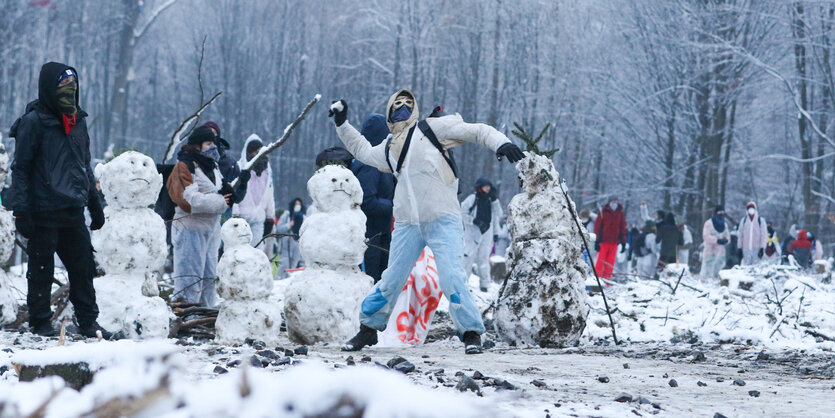 Aktivisten und Schneemänner im Wald