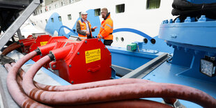 Zwei Servicetechniker stehen neben einem mobilen Kran der Landstromanlage am Cruise Center Altona