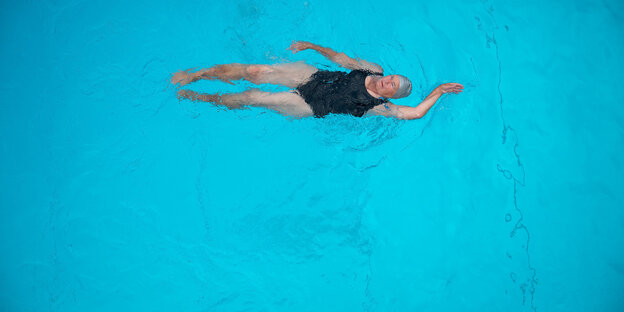 Rückenschwimmerin im blauen Becken