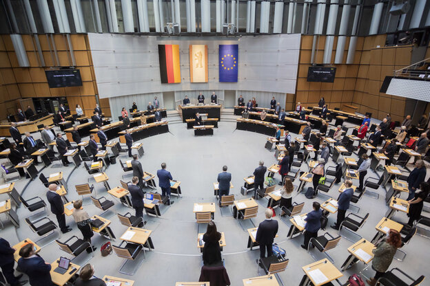 Das Bild zeigt den Sitzungssaal des Abgeordnetenhauses von Berlin mit stehenden Abgeordneten.