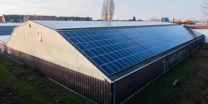 Eine Photovoltaikanlage erstreckt sich über ein komplettes Dach eines Gewerbebetriebes.