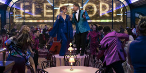 Dee Dee Allen (Meryl Streep) und Barry Glickman (James Corden) tanzen auf dem Tisch, andere Menschen in Ballkleidung tanzen um sie herum