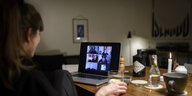 Eine Frau sitzt während der Corona-Pandemie an einem Tisch in ihrer Wohnung vor einem Laptop, während sie mit weiteren fünf Personen an einer Videokonferenz mit der Videokonferenzanwendung Zoom teilnimmt.