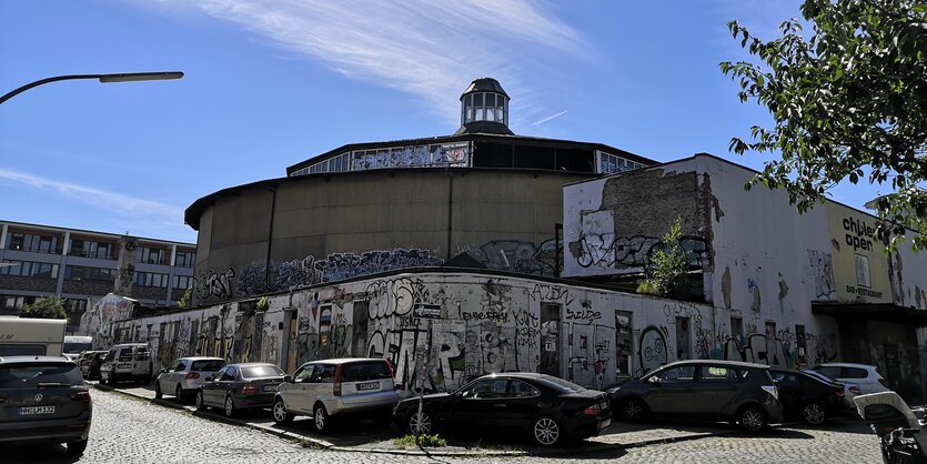 Rundes Gebäude mit Türmchen unter leicht bewölktem Himmel