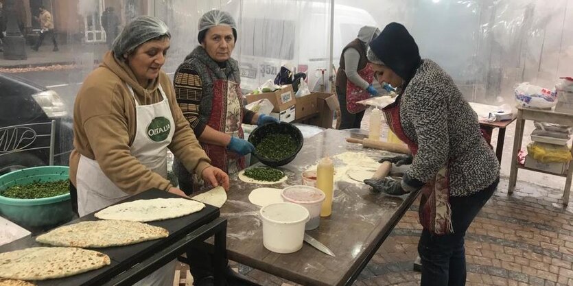 Drei Frauen bei der Herstellung von Fladenbrot