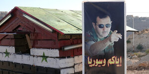 Ein Postenhäuschen steht an der Brücke von Rastan mit einem Bild von Präsident Baschar al-Assad