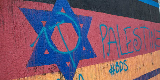 Ein Judenstern und die Aufschrift Palestine und ein Hashtag BDS auf der Berliner East Side Gallery