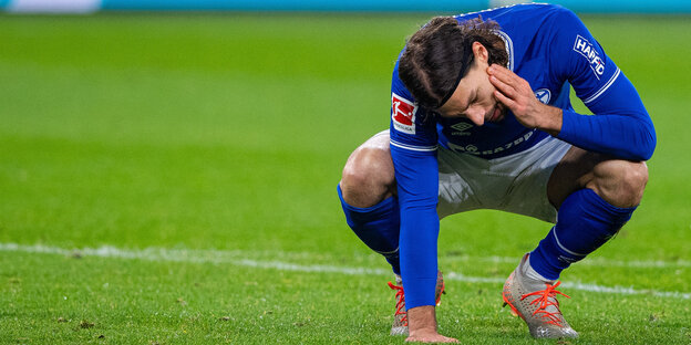 Schalkes Benjamin Stambouli hockt im Strafraum und fasst sich an den Kopf