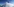 Eine Frau auf einem Berggipfel bei blauem Himmel vor Bergpanorama