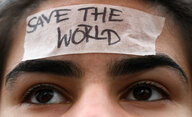 Eine Schülerin trägt während der Demo «Fridays for Future» ein Band mit der Aufschrift «Save the World» auf ihrer Stirn.