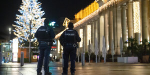 Menschenleere Fußgängerpassage mit Weihnachtsbaum und 2 Polizisten
