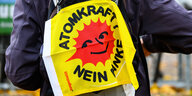 ein Demonstrant hat sich auf den Rücken eine Fahne mit der Aufschrift "Atomkraft nein Danke" gehängt